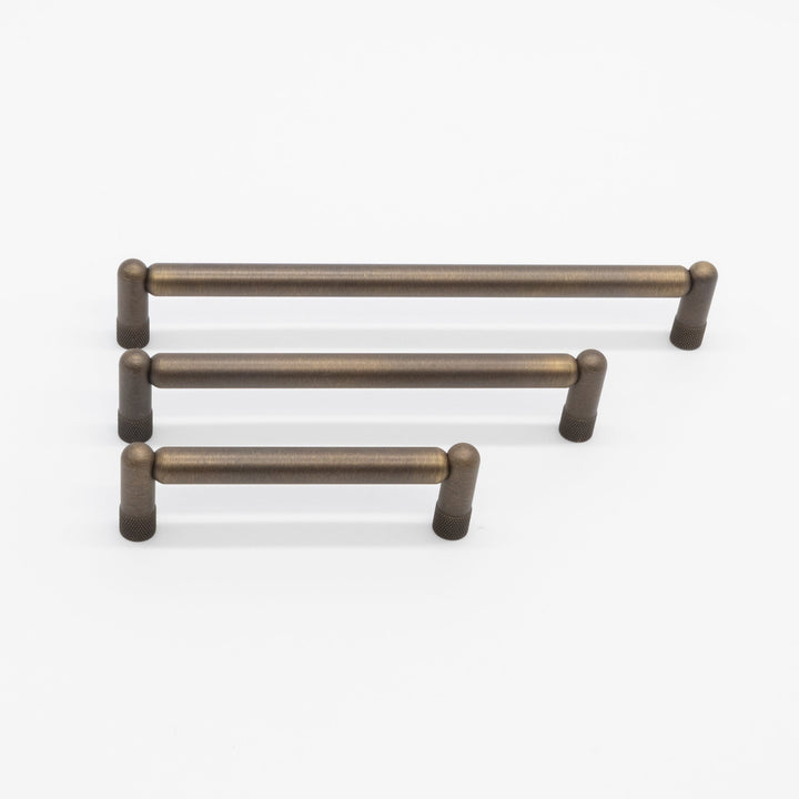 Set of three antique english cabinet handles on a white background