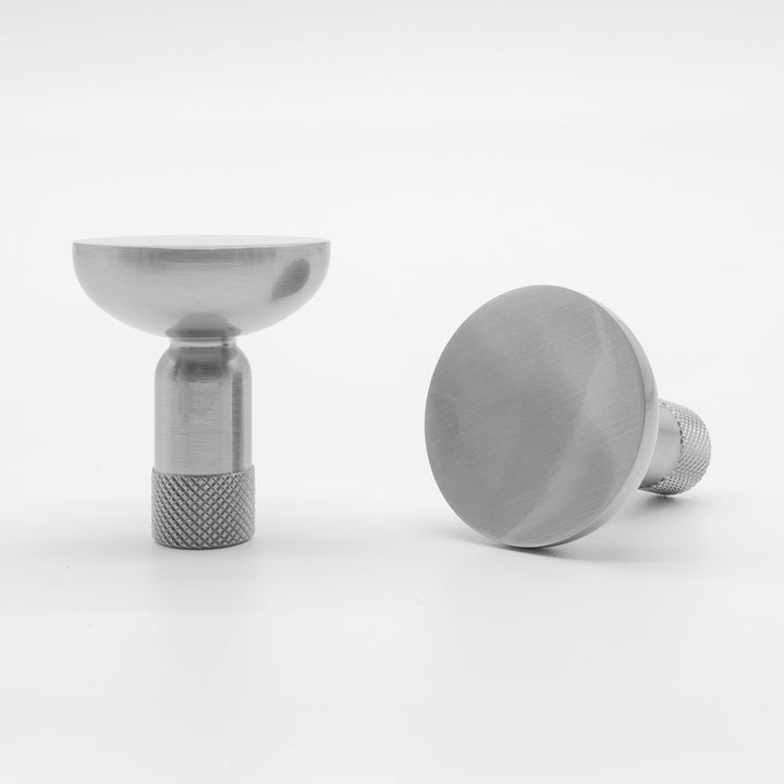 Two Hapny Knurled cabinet knobs in a satin nickel finish, one standing and one angled lying down.