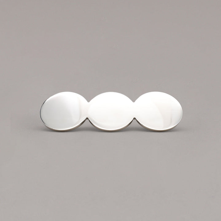 Statement polished nickel circular cabinet pull on a gray background