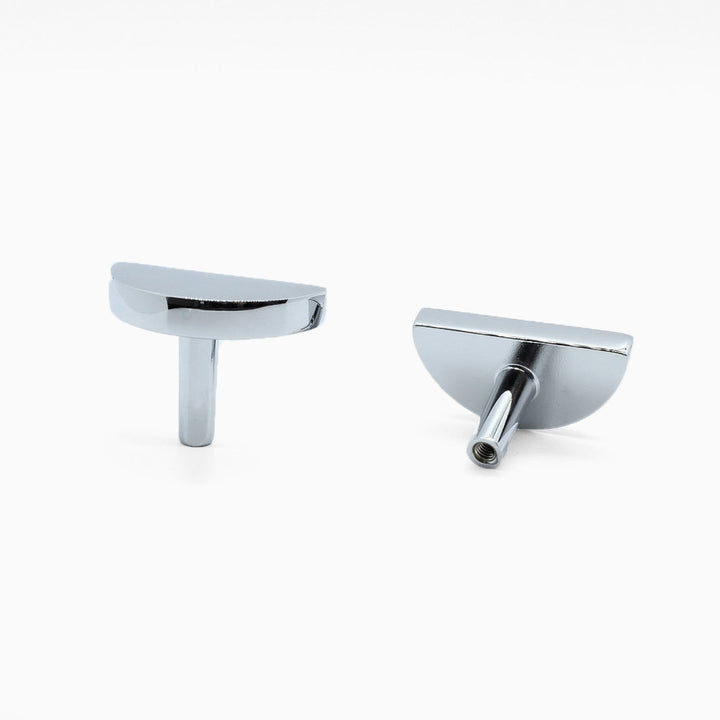 Two Polished Chrome Half Circle Cabinet knobs, one standing and one rear-facing while laying down.