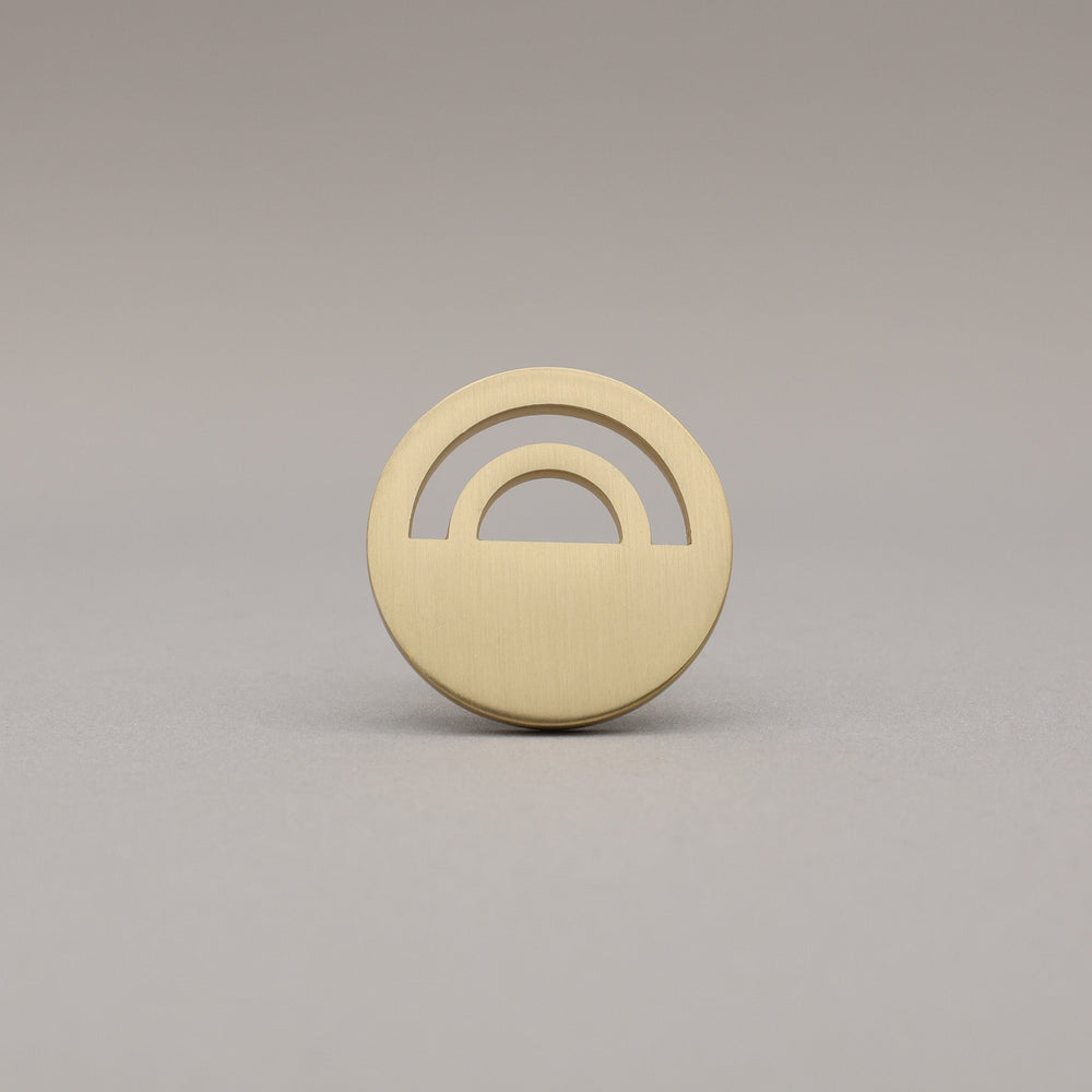 Horizon Satin Brass Knobs on grey background.