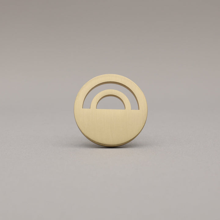 Horizon Satin Brass Knobs on grey background.