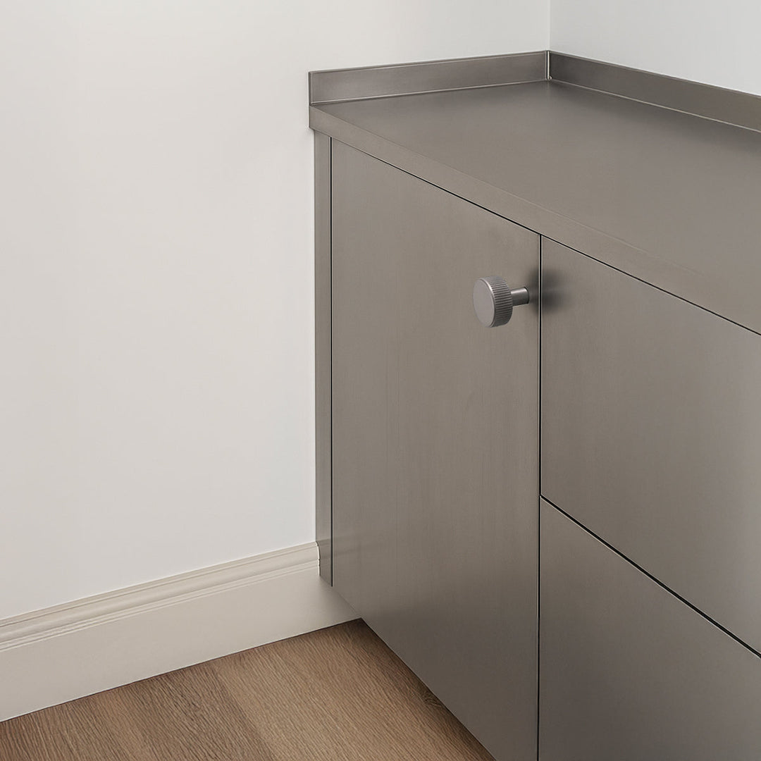 Ribbed satin nickel knob on stainless steel.